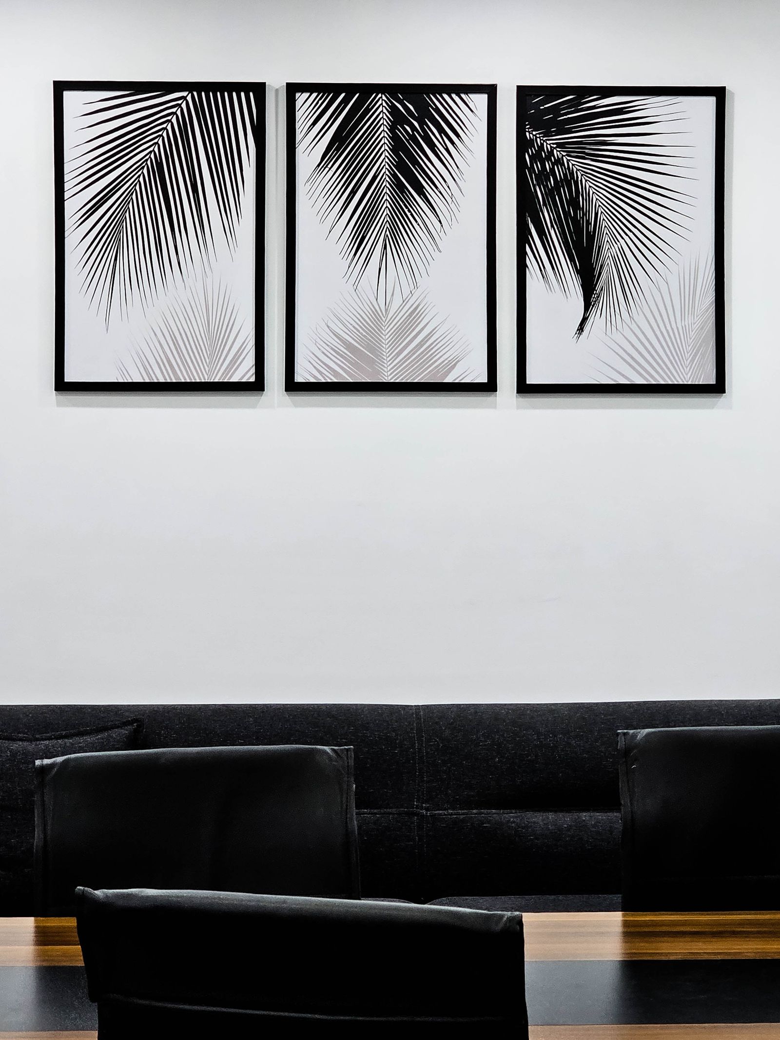 Quadros emoldurados decorando a parede de uma sala de reuniões corporativa