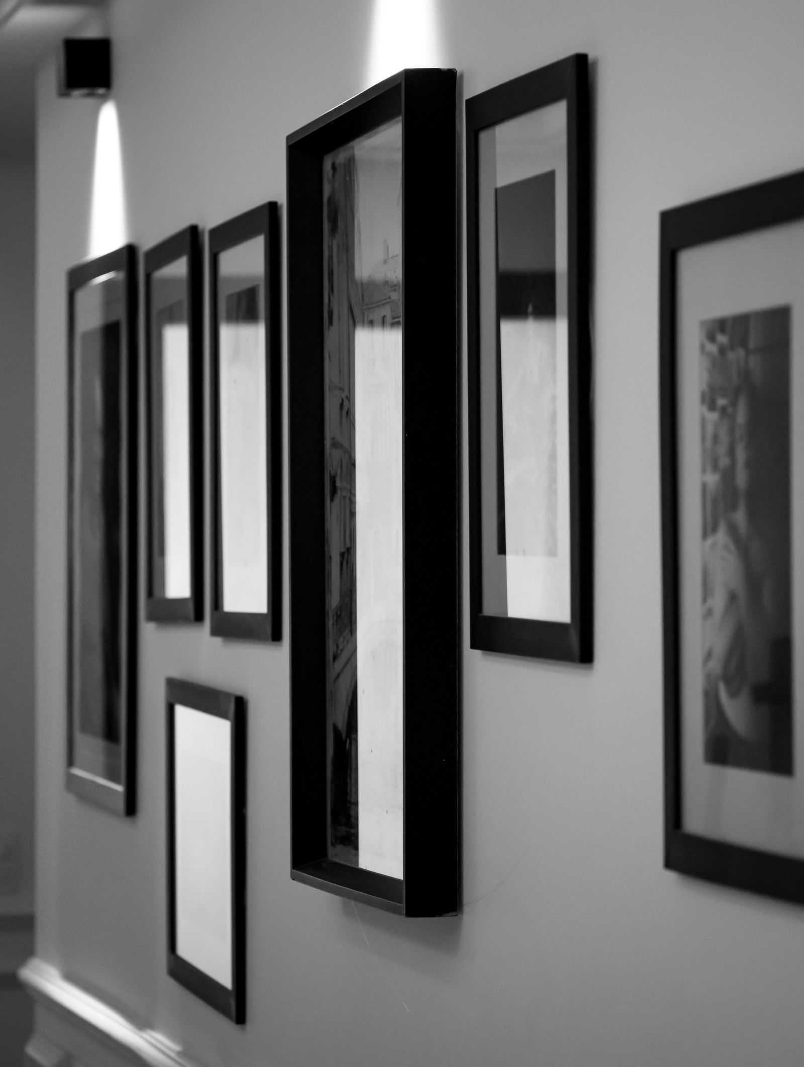 Composição de quadros emoldurados dispostos na parede, comparando formatos de porta-retrato e moldura